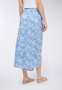 Gonna maxi con motivo floreale blu, dotata di uno spacco laterale e realizzata in tessuto leggero. Presenta una texture liscia e una vestibilità comoda e rilassata.