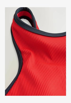 Rode ribstof met een zwarte rand. Heeft een mouwloos ontwerp en een zachte textuur, met een gladde afwerking en subtiele verticale lijnen.