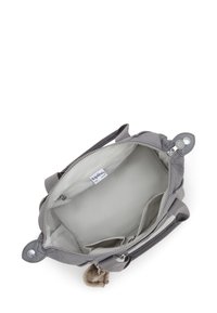 Graue Stoffhandtasche mit zwei Griffen, Reißverschluss und Innentaschen. Sie verfügt über ein weiches Futter und einen kleinen, pelzigen Anhänger am Reißverschluss.