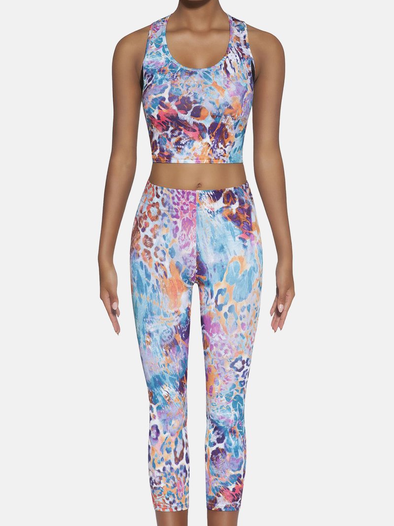 Wielokolorowy zestaw sportowy z krótkim topem i dopasowanymi legginsami 7/8. Wzór zawiera żywe plamy niebieskiego, pomarańczowego i fioletowego w stylu lamparta.