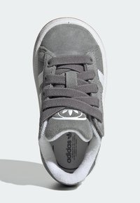 Zapatillas de ante gris con acentos en blanco, puntera redonda, cordones planos y suela de goma. Con logo en la lengüeta y forro textil.