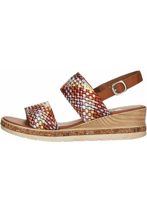 Kile sandal med flerfarvede vævede remme, brun justerbar ankelrem med sølvspænde og tekstureret tan korksål med blomstermønster.