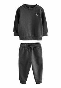 Ensemble de survêtement gris foncé composé d'un sweat-shirt à col rond et de joggings à taille élastique. Les deux pièces présentent des poignets côtelés et un petit détail de logo.