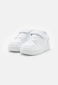 Białe skórzane sneakersy z teksturowanym wykończeniem, z rzepem i sznurowaniem, otworem wentylacyjnym na palcach oraz gumową podeszwą.