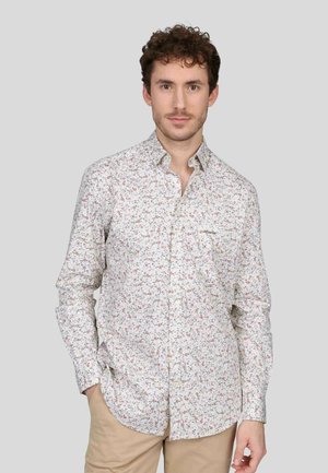 Chemise blanche avec motif floral coloré, col à boutons, manches longues, poche poitrine et ourlet légèrement arrondi. En coton.