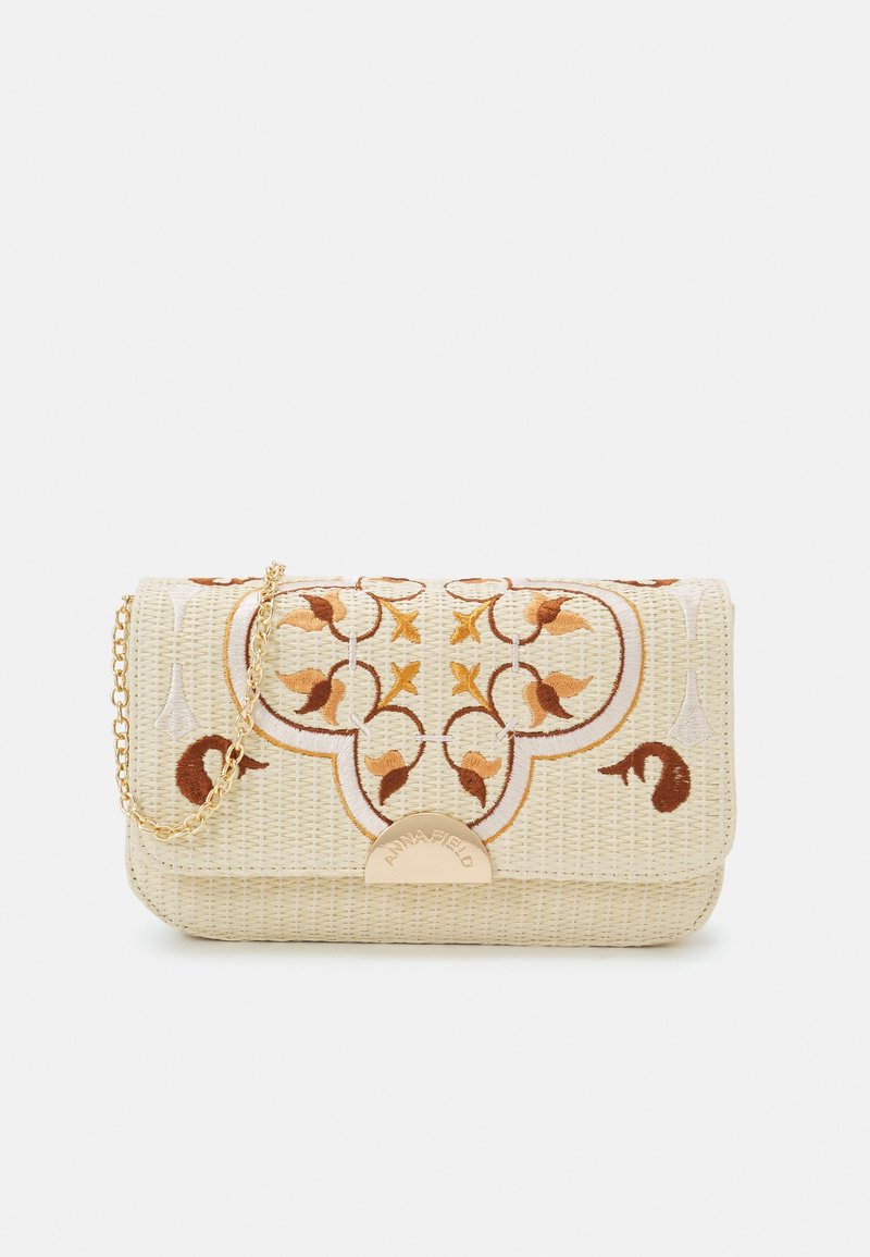 Pochette rectangulaire beige tissée avec bandoulière chaîne dorée, broderie florale marron et jaune, et fermoir doré gravé du nom de la marque.
