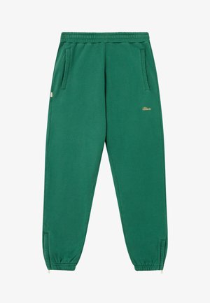 Joggers de algodón verde con cintura elástica, bolsillos laterales y detalle de logo dorado; tobillos ajustados con puños elásticos.