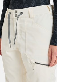 Helle beige Skihosen mit glatter Textur, verstellbarem Kordelzug und einer Reißverschlusstasche. Verfügt über eine taillierte Passform und verstärkte Nähte.