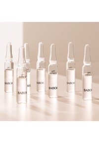 Ampoules en verre clair avec une forme effilée, étiquetées "LIFT EXPRESS BABOR", contenant un liquide clair, disposées en groupe.