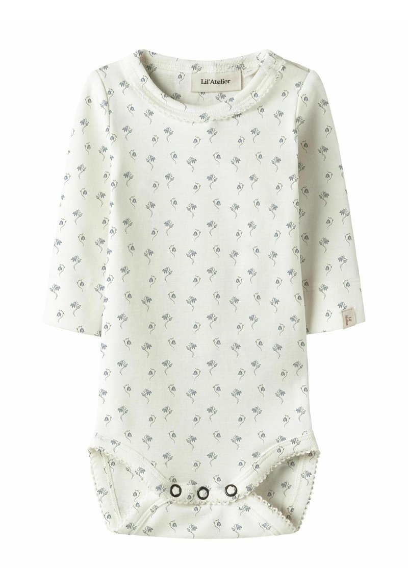 Hvit langermet body med små grå blomsterprint. Den har rund hals og knapper i bunnen for enkel påkledning. Mykt stoff.