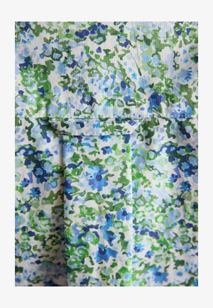 Sinine ja roheline lillemustriga kangas, millel on õmmeldud tasku ja volditud detail valgel taustal.