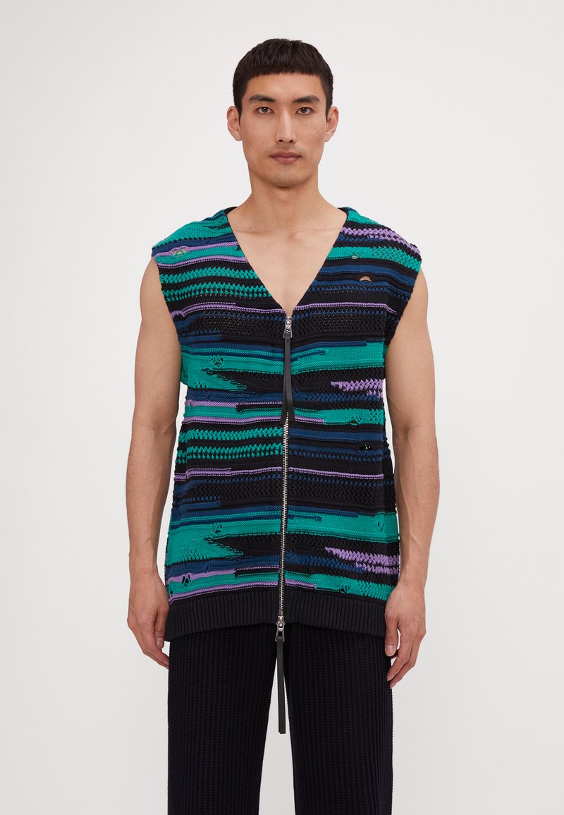 Gilet en tricot avec un décolleté en V profond et une coupe sans manches, présentant des rayures horizontales vertes, noires et violettes. Fermeture éclair à l'avant et ourlet côtelé.
