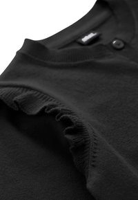 Pull noir en maille avec un col rond, détail de boutons près du col et bordure froncée le long de la couture de l'épaule.