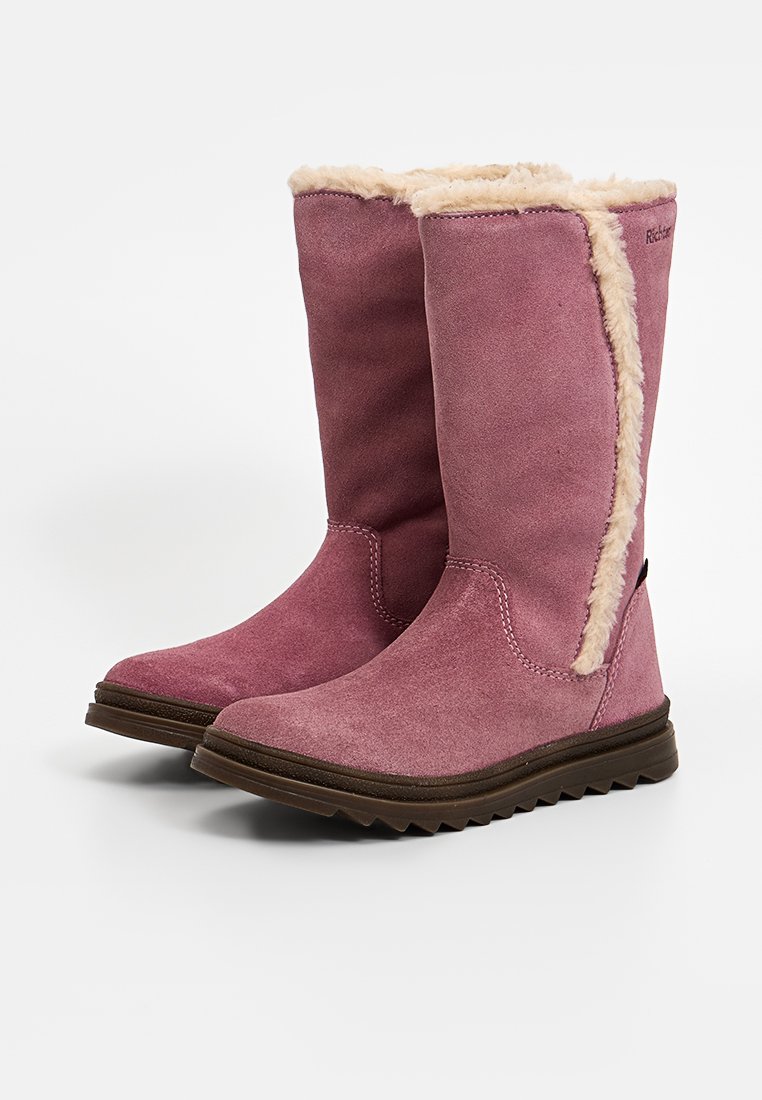Botas de ante rosa hasta la rodilla con forro de piel sintética y suela de goma texturizada. Presenta detalles cosidos y acentos laterales en contraste.
