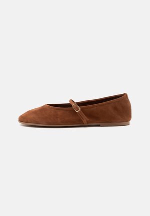 Chaussure plate en daim marron avec un bout pointu et une fine bride unique avec une petite boucle dorée sur le dessus.
