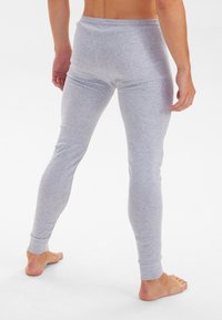 Gray, fitted leggings made of soft fabric, featuring a tapered design and ribbed cuffs. Visible seams along the sides and rear.