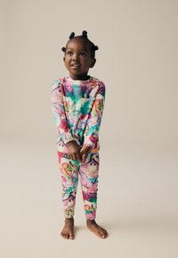 Ensemble de pyjama coloré à manches longues avec un mélange de motifs de graffiti en rose, vert et bleu ; fabriqué en tissu doux et à coupe près du corps.