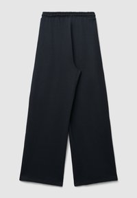 Schwarze weit geschnittene Hose mit elastischem Bund, flach auf einem hellen Hintergrund ausgelegt.