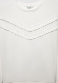 Weißes Sweatshirt mit Rundhalsausschnitt, das zwei horizontale Lagen strukturierter Fransen über der Brust sowie einen glatten Stoffabschluss aufweist.