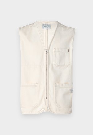 Beige mouwloze vest gemaakt van katoen, met een rits aan de voorkant, twee grote voorzakken en een klein label aan de onderste rechterzijde.