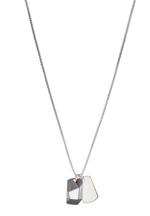 Srebrny naszyjnik łańcuchowy z dwoma geometrycznymi wisiorkami, jednym w ciemnoszarym kolorze z zaokrąglonym brzegiem, a drugim w lśniącym srebrze, połączonym złotym akcentem.