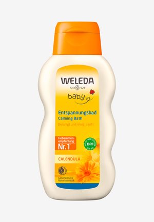 Bouteille de bain apaisante pour bébé Weleda, blanche avec un capuchon orange. Caractérisée par une étiquette jaune avec des graphiques de fleurs, du texte en allemand et un logo de certification biologique.