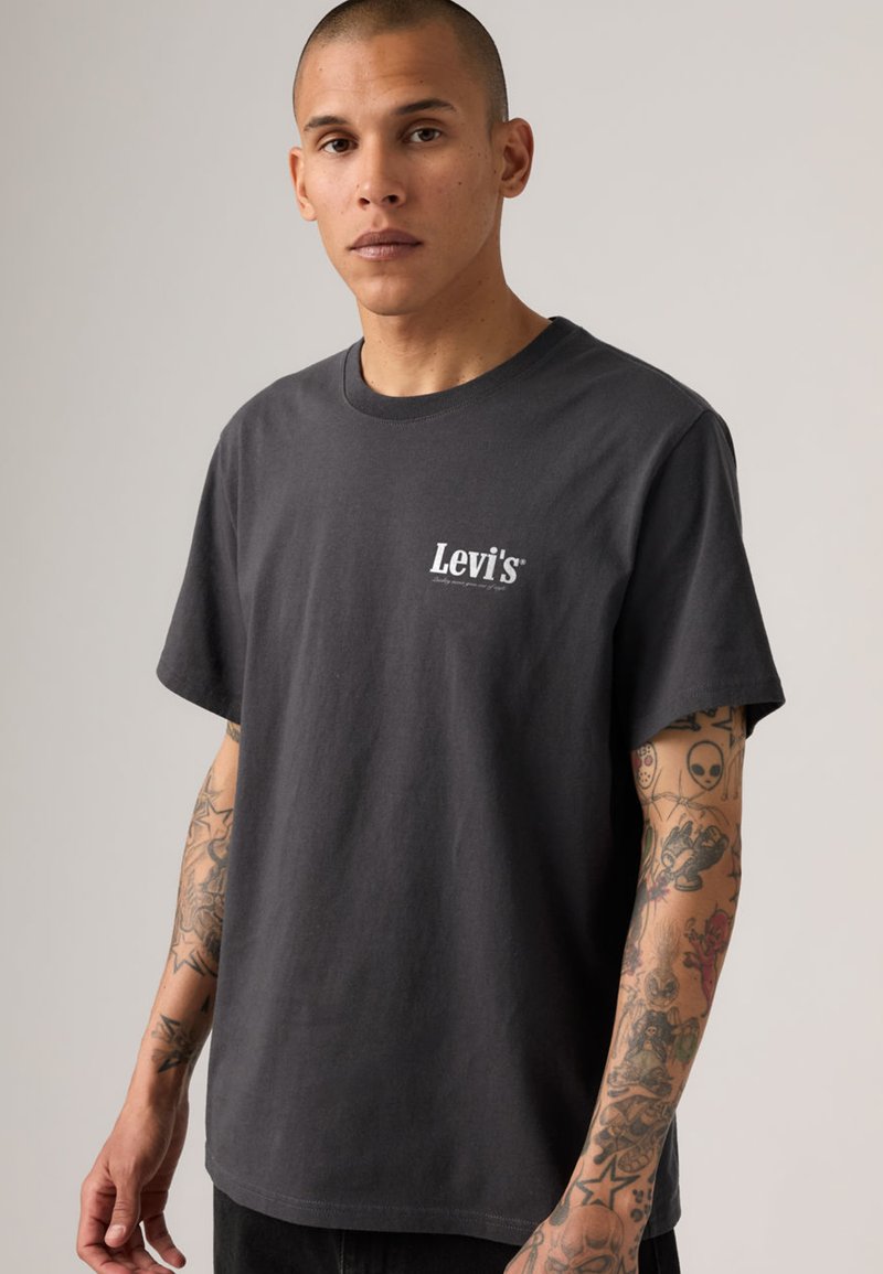 T-shirt en coton noir avec un col rond et des manches courtes, arborant un petit logo blanc "Levi's" sur la poitrine.