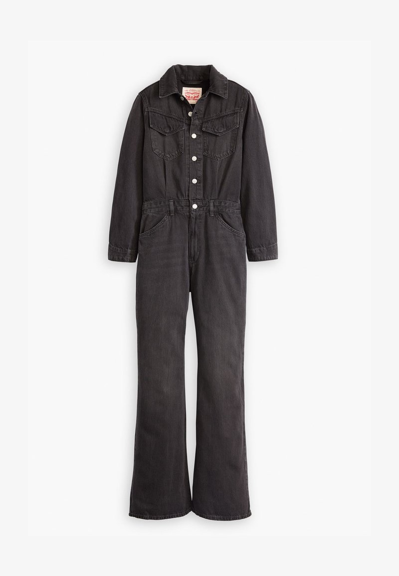 Combinaison en denim gris foncé. Elle présente un col, des poches avant, des boutons et des jambes évasées pour une silhouette ajustée.