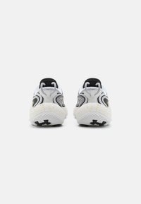 Witte en zwarte sportschoenen met golvend ontwerp, rubberen zolen en grijze accenten. Bevat een gestructureerde achterkant met contrasterende patronen.
