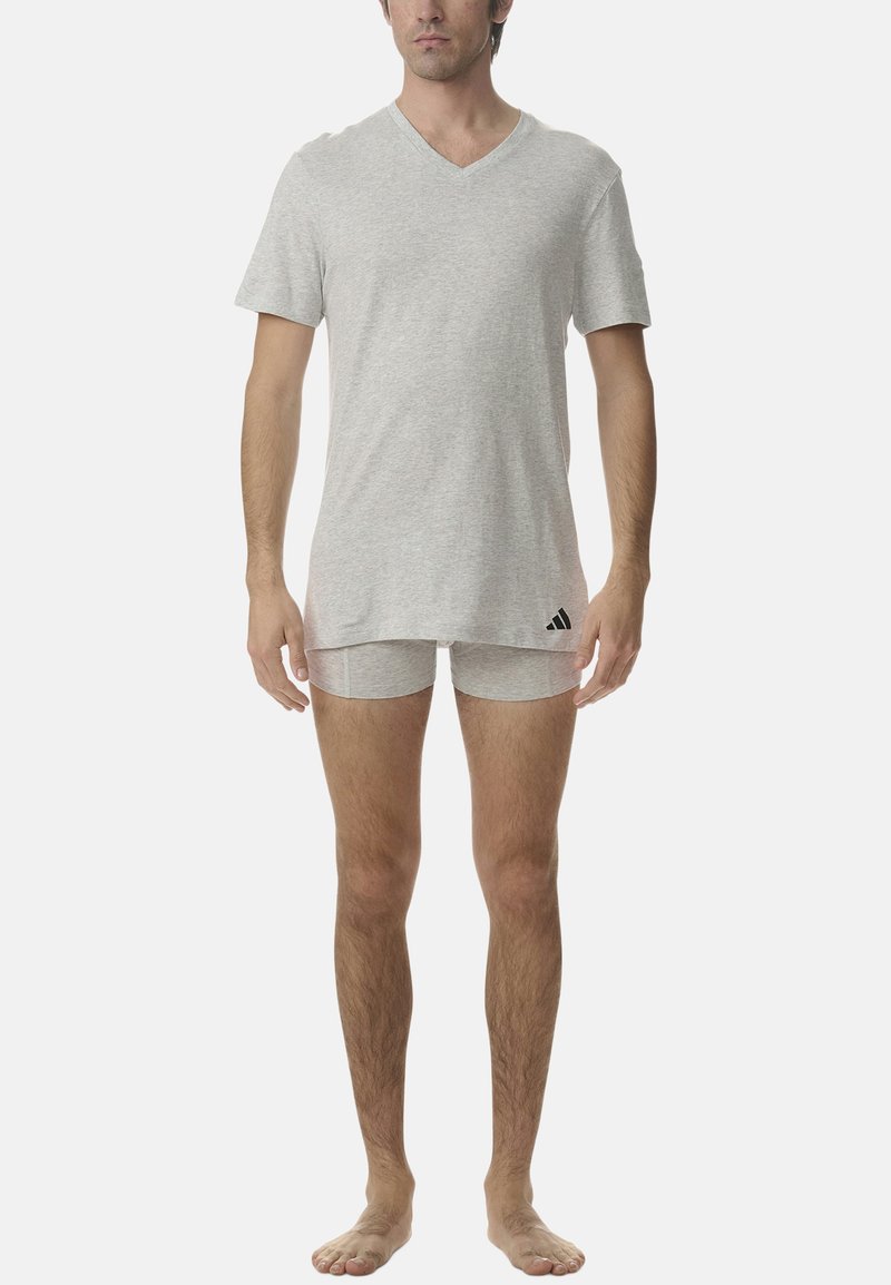 Szary t-shirt w serek oraz dopasowane majtki wykonane z miękkiej, teksturowanej tkaniny. Koszulka ma delikatnie zaokrąglony dół oraz logo adidas na dole.