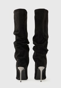 Botas negras de tacón alto hasta la rodilla con un acabado liso y texturizado y un diseño fruncido, con tacones de aguja metálicos.