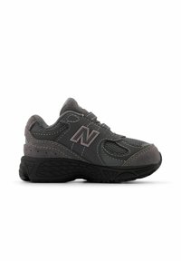 Scarpa sportiva grigia con materiali in rete e suede, suola in gomma, cuciture dettagliate e un logo prominente di lato.