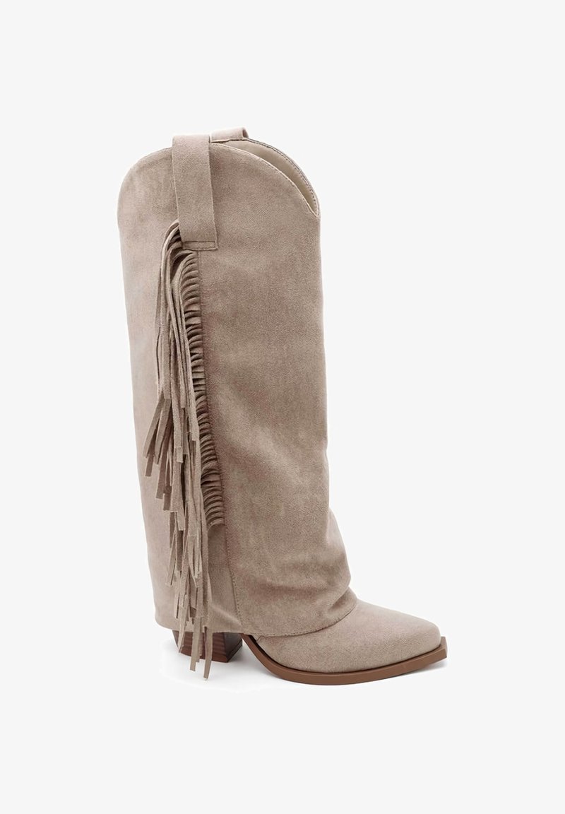 Botte de cheville en daim beige au design décontracté, à bout carré, avec une frange décorative sur le côté. Présente un petit talon empilé.