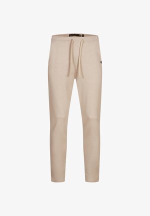 Beige tapered sweatpants with elastic waistband and drawstring, featuring a small side logo tag.