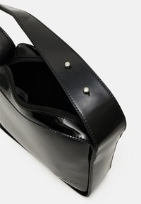 Borsa in vera pelle nera con un design elegante, dotata di una tasca interna con zip e chiusure a scatto. Texture liscia e accenti hardware minimali.