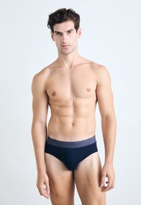 Zwarte slipjes met een grijze tailleband met opdruk. De stof ziet er soepel en rekbaar uit, met een aansluitend ontwerp en minimale naden.