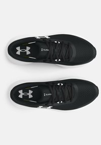 Baskets de sport noires avec une tige en mesh respirant, des lacets plats, une semelle blanche et un accent logo blanc sur le côté et sur la languette.