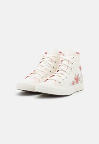 Bílé plátěné vysoké tenisky s růžovými a šedými květinovými vzory, texturovanou gumovou podešví a tradičním šněrováním.