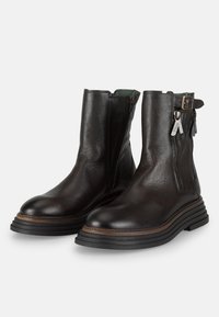 Botas de tobillo de cuero negro con un acabado texturizado, que cuentan con cremalleras laterales, un detalle de hebilla y un diseño de suela estratificada y acanalada.
