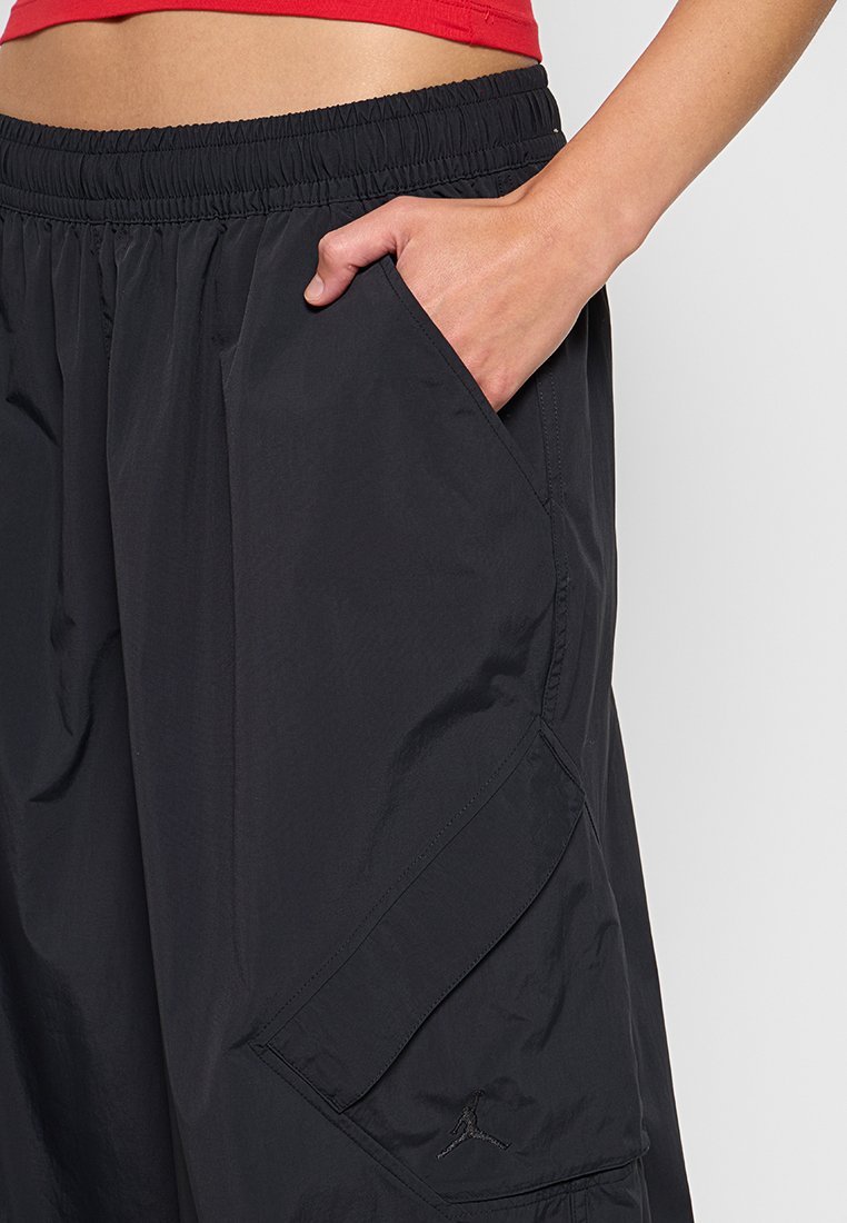 Pantaloni cargo neri realizzati in tessuto leggero, con vita elasticizzata, tasche laterali e un logo ricamato sulla parte inferiore della gamba.