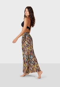 Maxihame, joka esittelee värikästä abstraktia kuviointia, valmistettu kevyestä kankaasta. Suunnittelussa on korkea vyötärö ja lennokas siluetti.