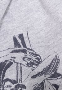 Grauer Baumwollstoff mit einem detaillierten schwarzen Druck von Händen und abstrakten Formen, der einen strukturierten visuellen Kontrast erzeugt.