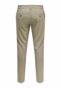 Pantaloni beige su misura con una texture liscia, dotati di due tasche posteriori con bottoni dorati e un design a gamba dritta.