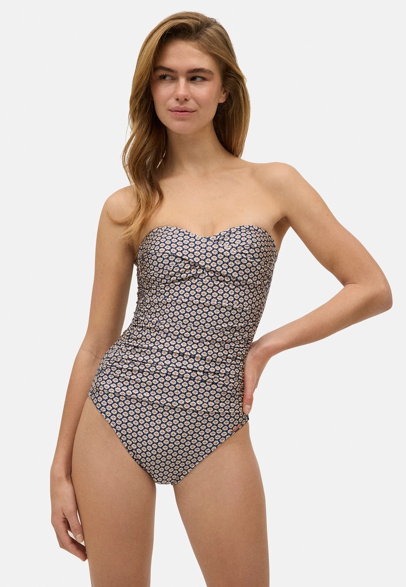 Bañador de una pieza sin tirantes en color azul marino con un estampado floral. Textura suave, diseño entallado y corte moderado en las piernas. Reunido sutil en el busto.