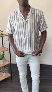 Kortærmet, knap-op skjorte med hvide og blå striber, en brystlomme og en afslappet pasform, parret med lyseblå skinny jeans.