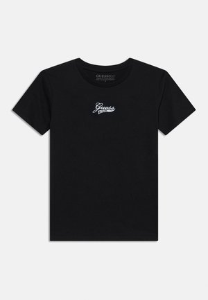 T-shirt noir à manches courtes et col rond avec le logo blanc "Guess EST. 1981" centré sur la poitrine.