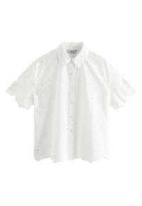 Camicetta bianca a maniche corte con orlo scallop, caratterizzata da un intricato ricamo ad occhio di pernice e una chiusura con bottoni davanti. Tessuto in cotone morbido.