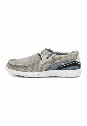 Zapatos ligeros tipo slip-on con parte superior de malla transpirable en color gris, detalles texturizados, acentos en negro y un talón con patrón en una suela blanca moteada.