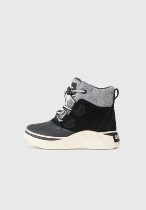 Bottines noires avec une tige en nubuck, col en feutre gris et semelle texturée blanche. Comprend des œillets et des lacets noirs avec un détail réfléchissant.