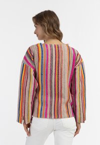Maglione a righe multicolore che presenta varie tonalità come rosa, blu e giallo, con una vestibilità ampia e un tessuto testurizzato.
